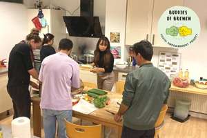 Foto: fünf junge Leute in einer Küche beim Gemüse schnippeln